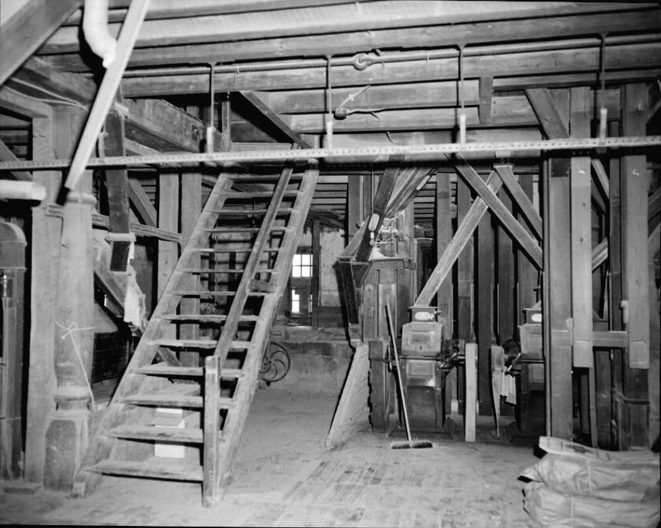 Picture 6 – Interior of the first floor of the Pleasant Valley Roller Mills, showing two of the four Case roller mills that the JHS acquired, along with part of the flour elevators just in back of the mills.