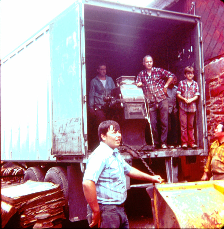 Picture 7 – Unloading one of the Case roller mills from the tractor trailer September 29, 1974.  Ron Buxton in plaid shirt leaning on the mill.