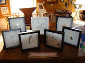 Image - Photo of seven framed art pieces by Karen Mount.  Each comprise sticks, pebbles, and seaglass.